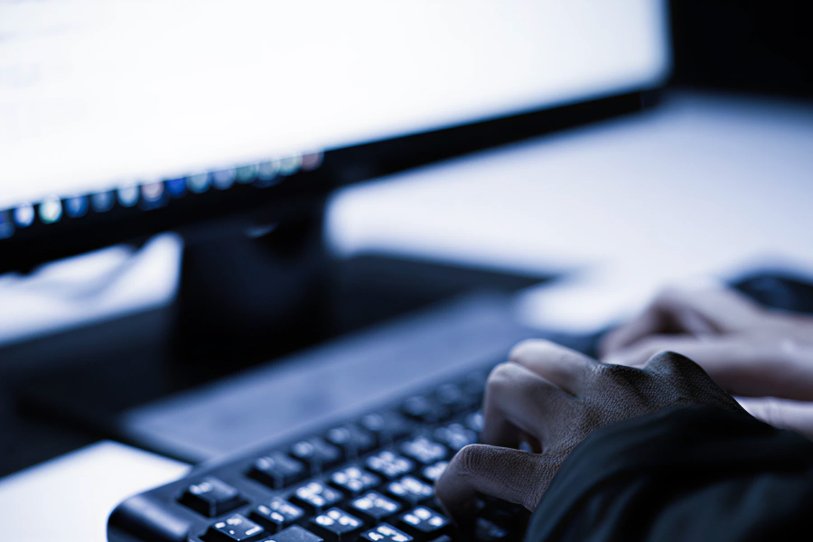 Hands typing on a keyboard in a dark office, highlighting the urgency of IT Emergencies.