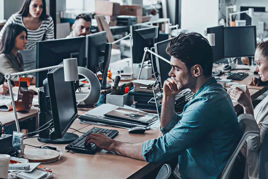 Office team working at computers, emphasizing the importance of strong security in the workplace.